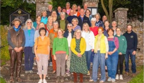 Members of a choir standing on church steps.