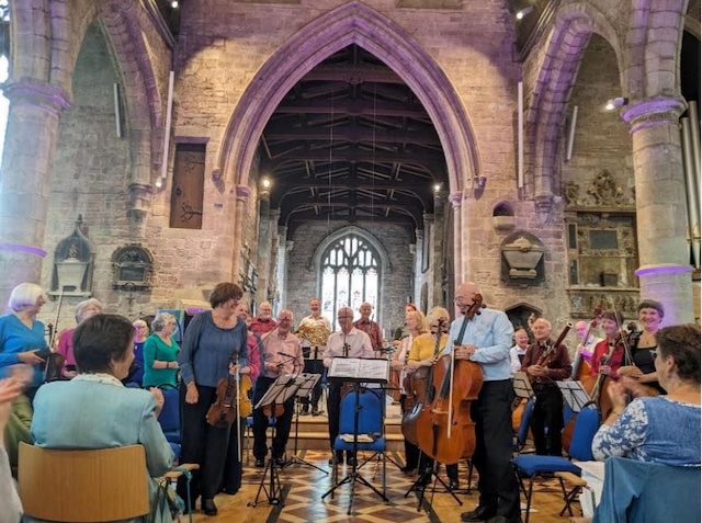 An orchestra playing in a church setting.
