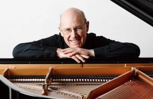 A pianist looking over an open grand piano